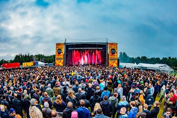 a large crowd of people are standing in front of a stage at a music festival in iceland.