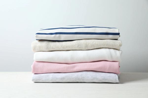 a stack of folded clothes on a white table .