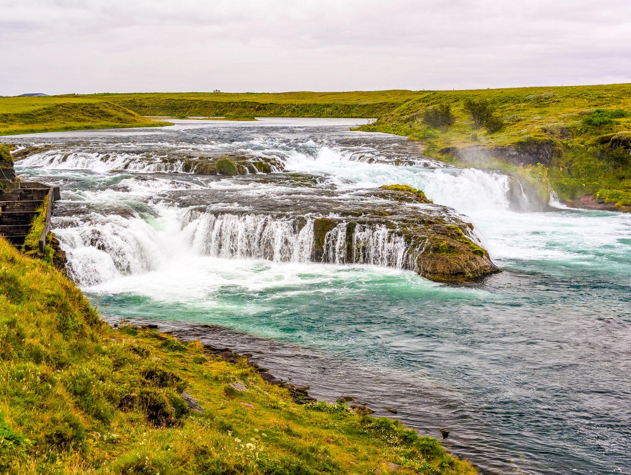 Río con una pequeña cascada rodeado de verde