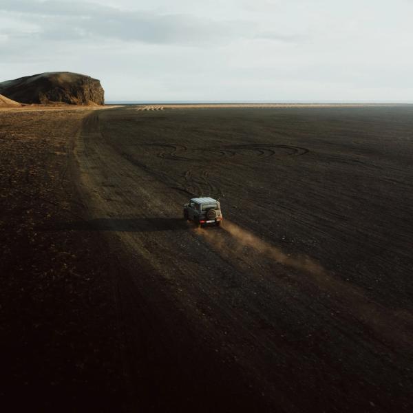 an aerial view of a jeep driving down a dirt road .
