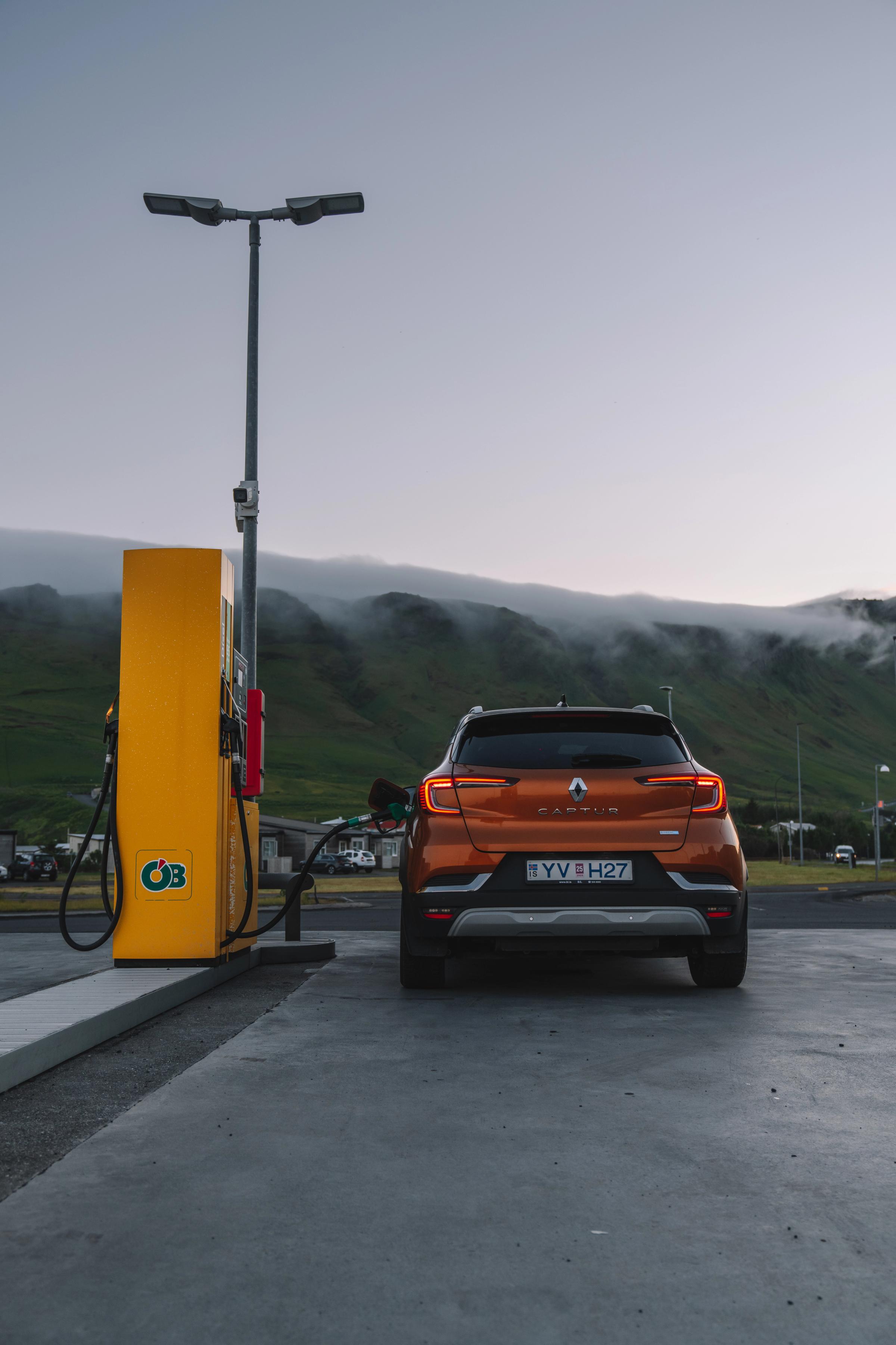 Renault Captur rear view parked at a fuel pump with misty hills in the distance