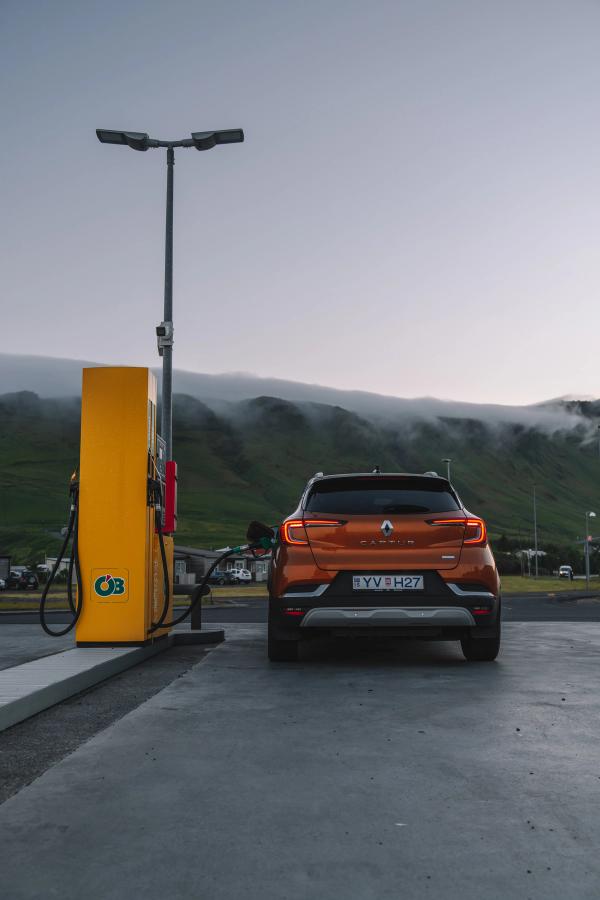Renault Captur rear view parked at a fuel pump with misty hills in the distance