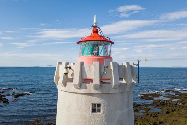 The tip of a white lighthouse from upclose