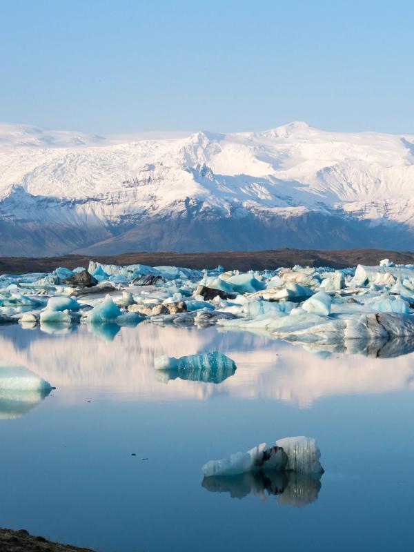 un lac rempli d'icebergs avec des montagnes en arrière-plan.