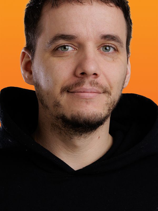 Hombre con barba y sudadera negra.