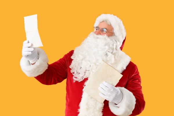 santa claus is holding a piece of paper and an envelope .