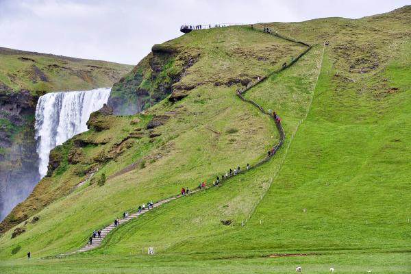 staircase going up a hill with a waterfall at the left side