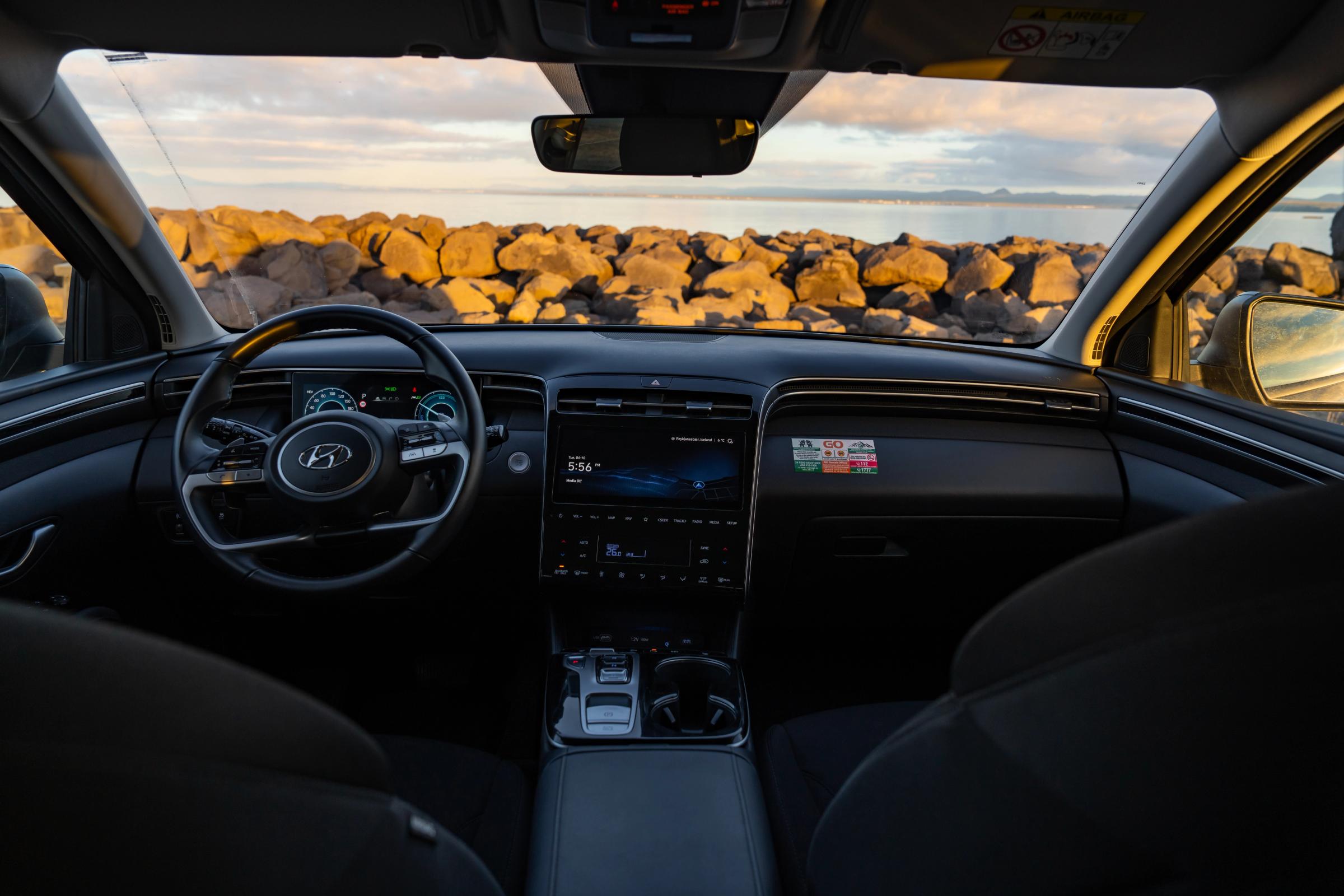 Hyundai Tucson front cabin seen from the rear seat, with centre console and rocky shoreline ahead