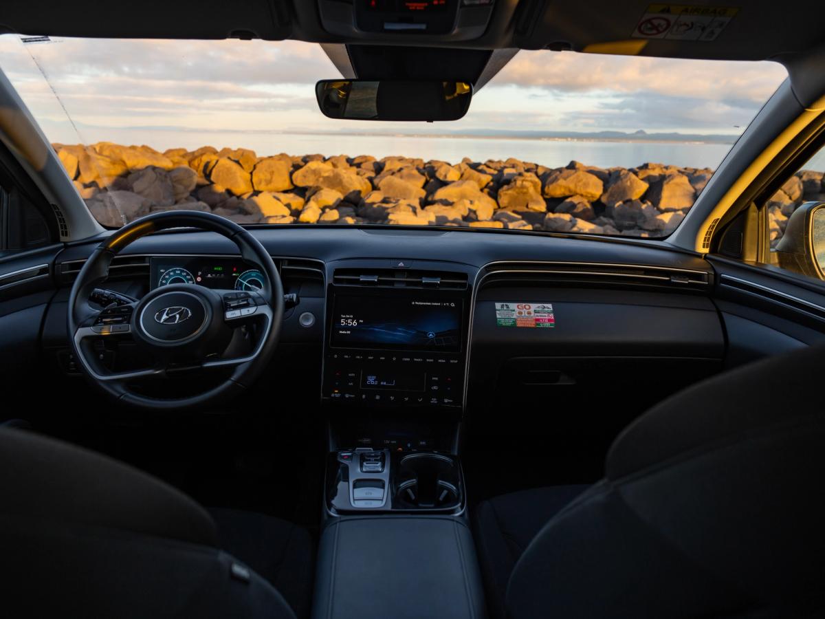 Vue de l’habitacle avant du Tucson Hyundai Tucson front cabin seen from the rear seat, with centre console and rocky shoreline ahead