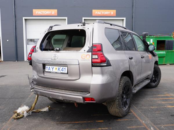 a toyota land cruiser is parked in a parking lot in front of a building .