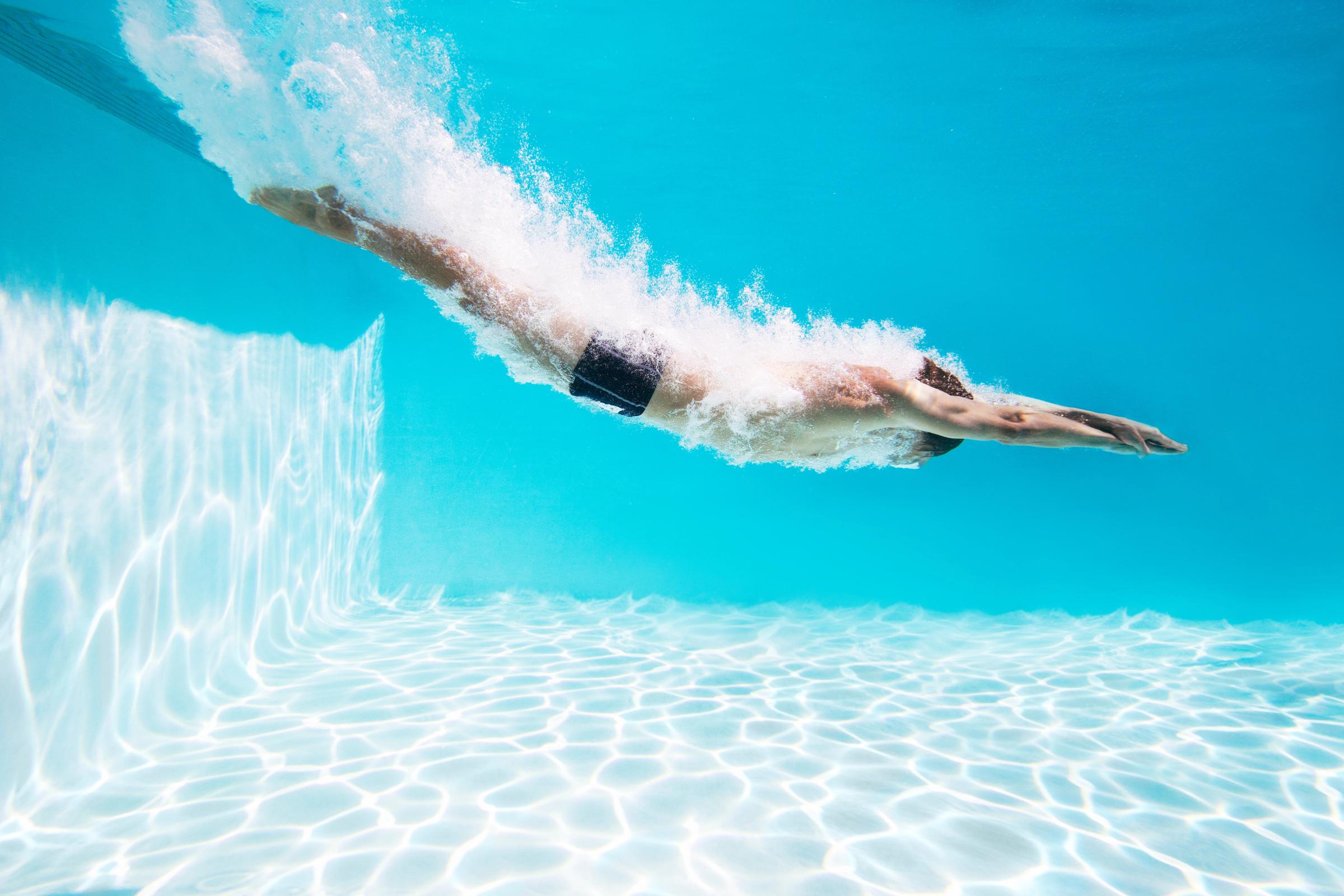 Men jumping in a pool