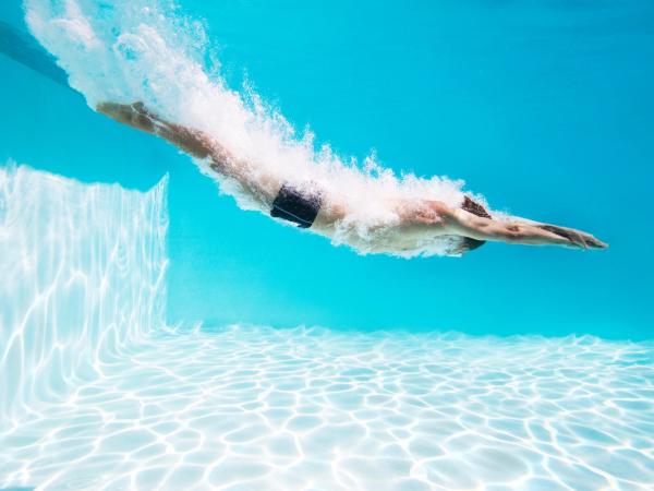 Men jumping in a pool