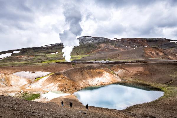 a couple of people standing on top of a hill next to Viti crater, Krafla