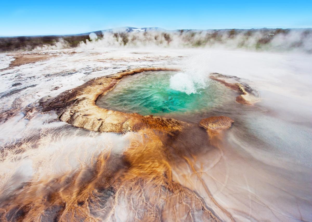 an aerial view of a hot spring with steam coming out of it at Hveravellir in north iceland.