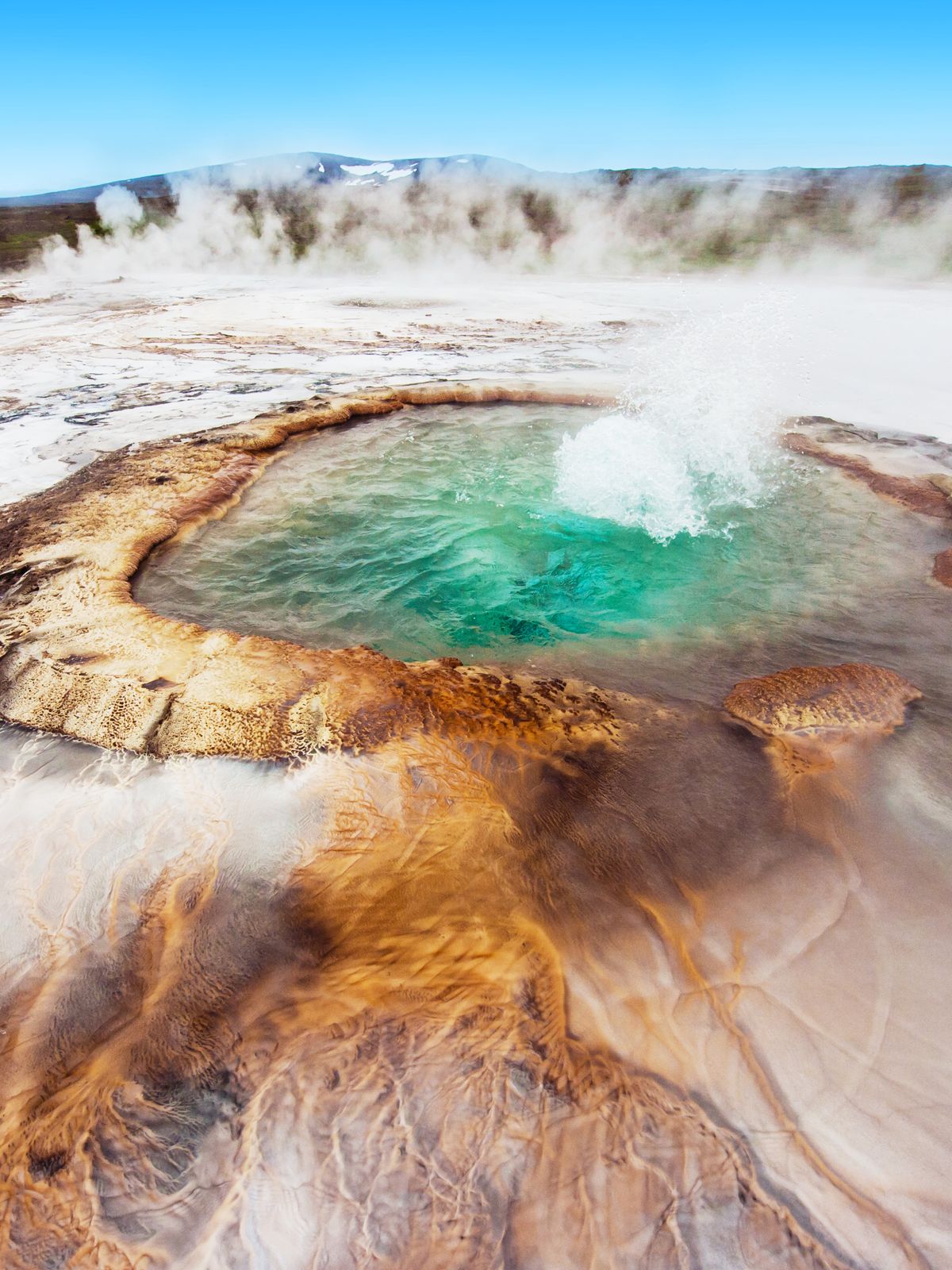 an aerial view of a hot spring with steam coming out of it at Hveravellir in north iceland.