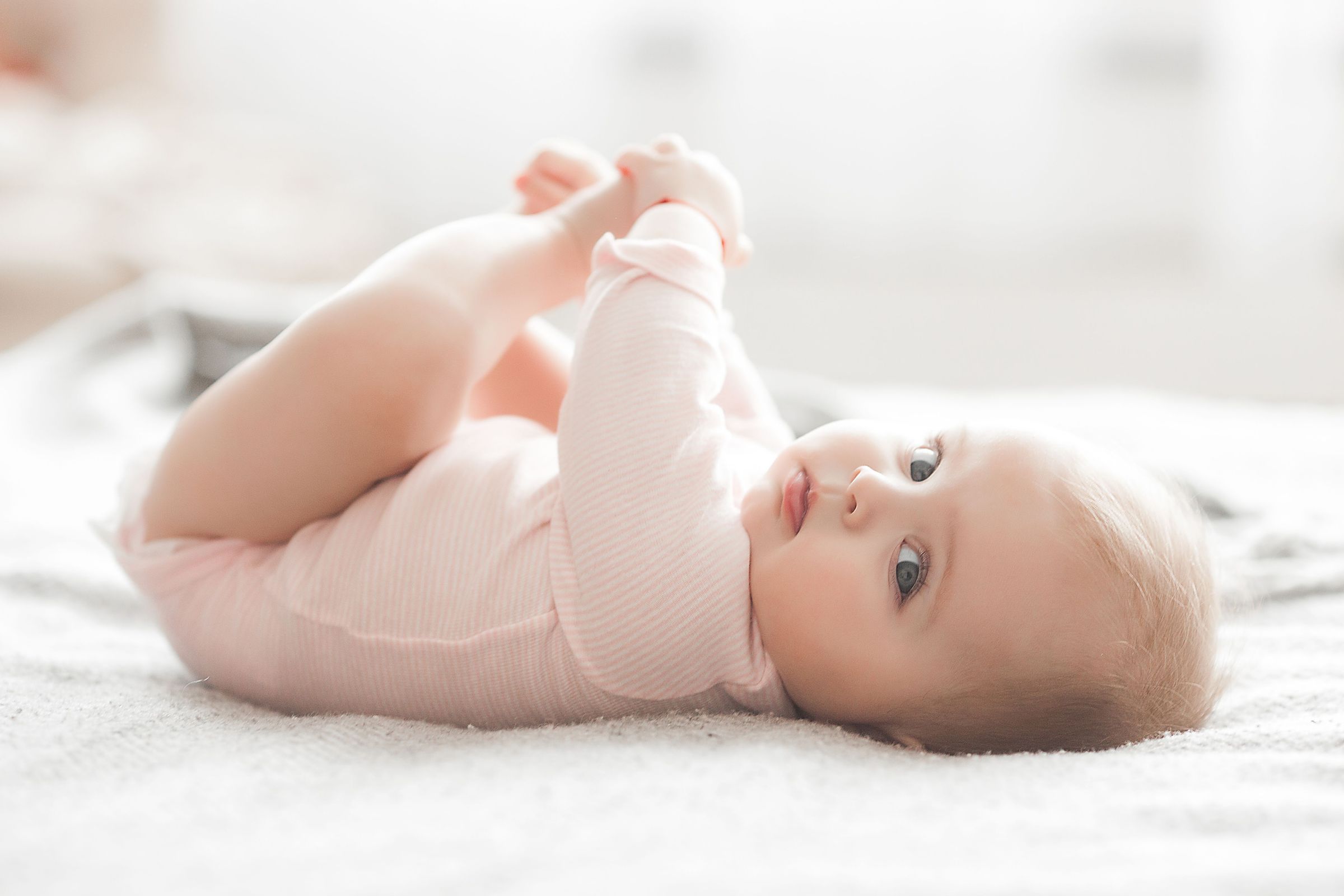 a baby is laying on its stomach on a bed .