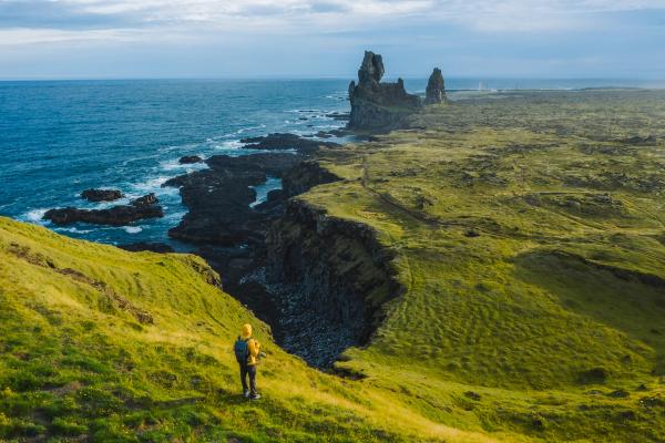 a person is standing on a cliff overlooking the ocean .