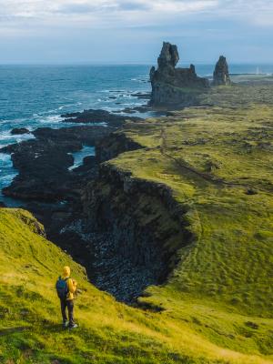 a person is standing on a cliff overlooking the ocean .