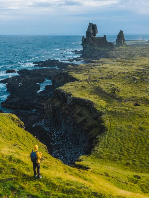 a person is standing on a cliff overlooking the ocean .