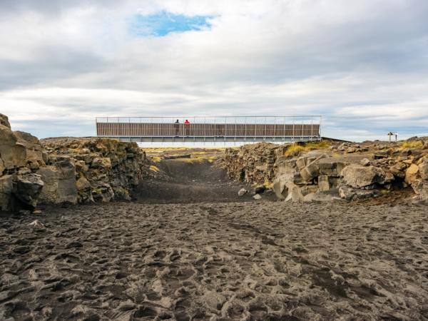 a bridge over a river in the middle of a rocky area .