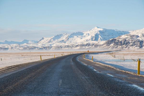 A road with a mountain covered in snow on the background