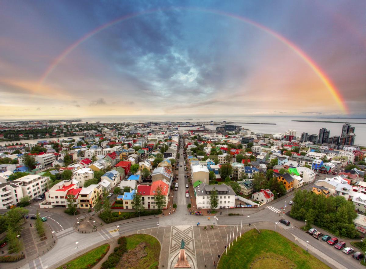 an aerial view of reykjavik with a rainbow in the sky .