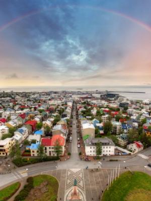 an aerial view of reykjavik with a rainbow in the sky .