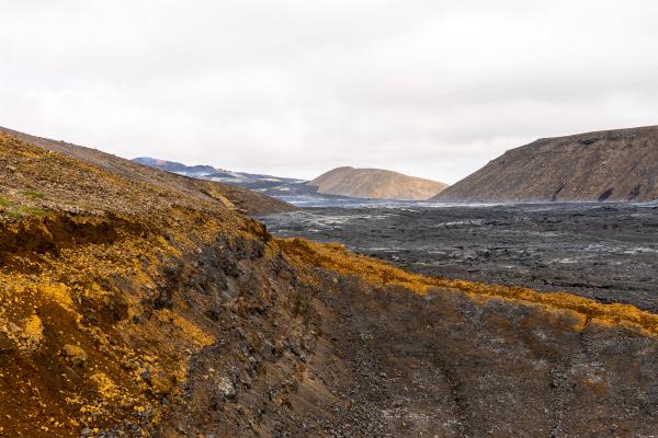 a dirt road going through a valley with mountains in the background, Geldingadalir