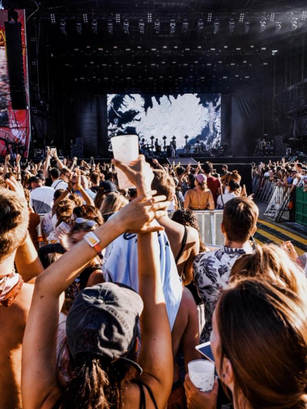 Gente delante de un escenario en un festival de música