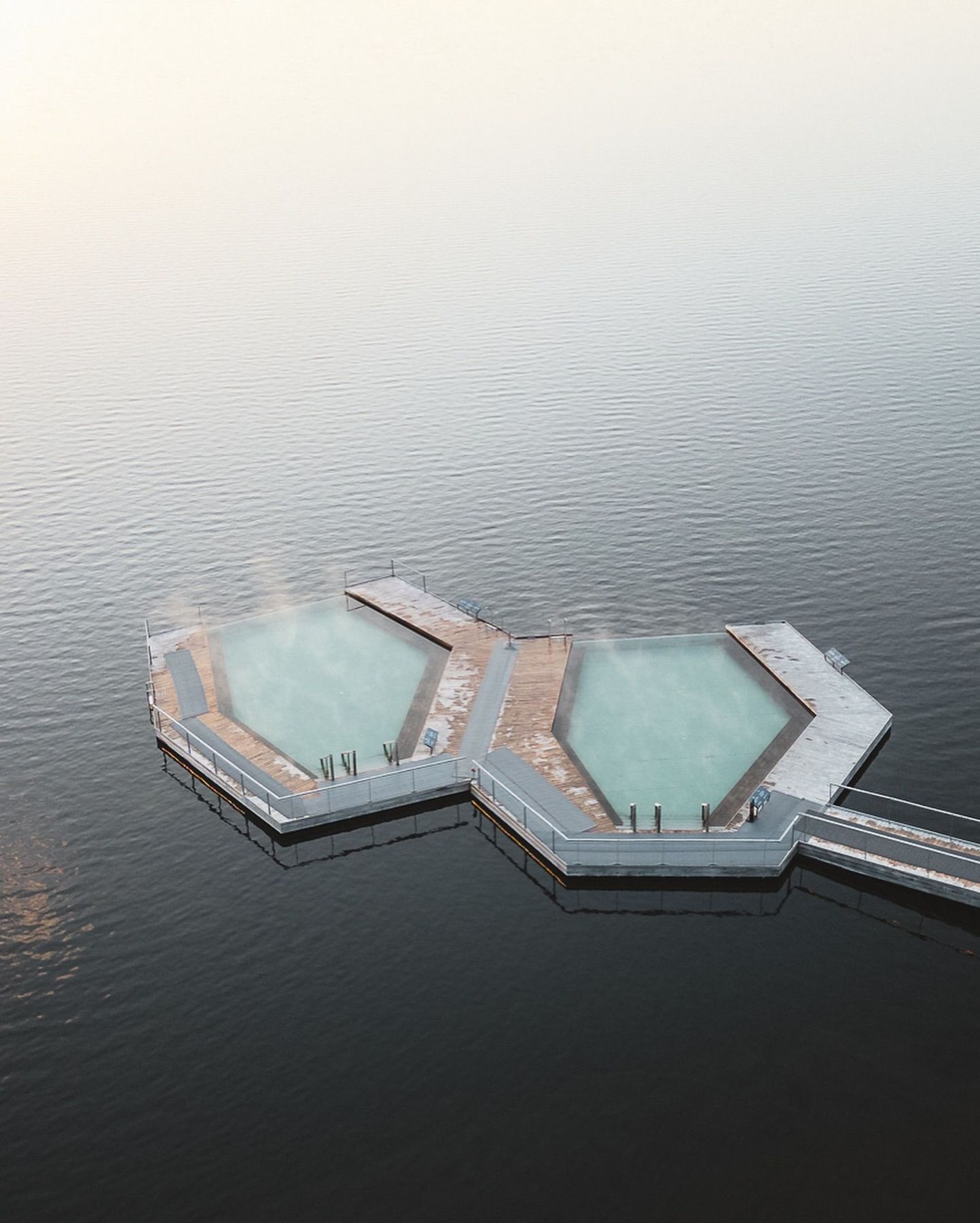 Drone shot of Vök Baths floating pools against the lake