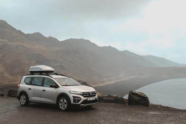 Maximizing Storage for Icelandic Adventures: Gray Minivan Rental with Roof Box A roof box attached to the top of a gray minivan rental car in Iceland