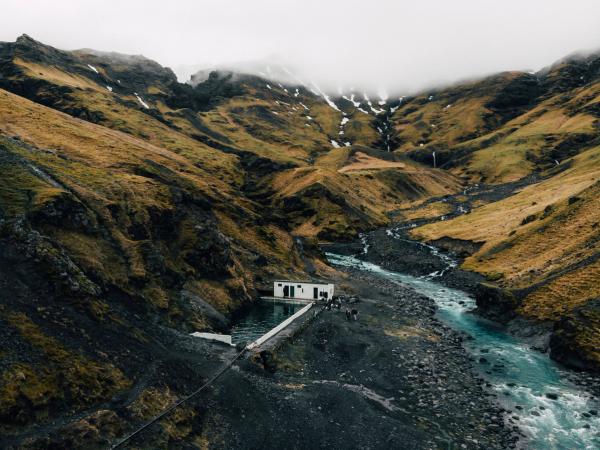 an aerial view of a house in the middle of a valley next to a river .