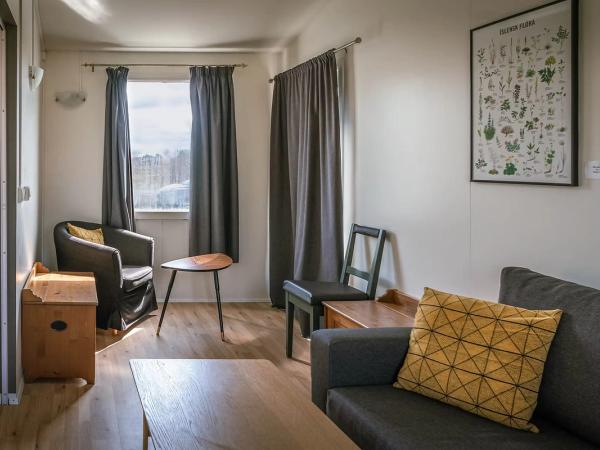 una sala de estar con un sofá, sillas, una mesa y un cuadro en la pared.