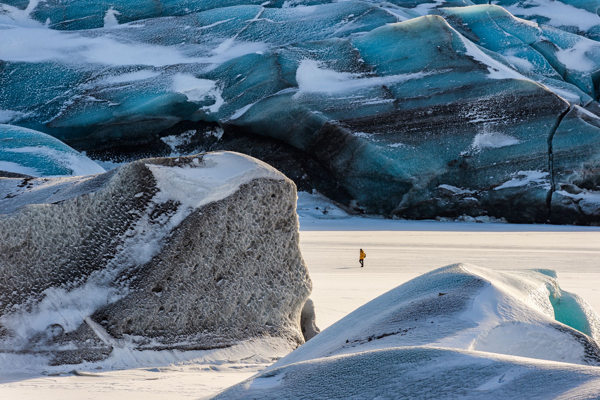 a person walking on a big glacier