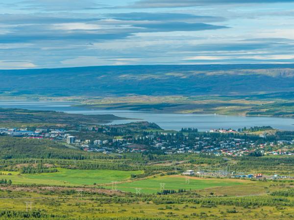 an aerial view of a city in the middle of a valley with a lake in the background .