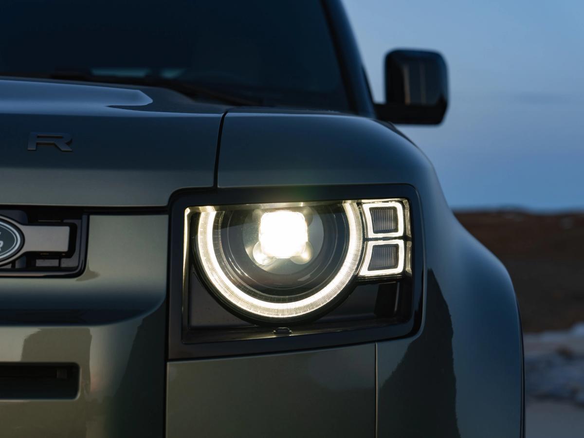 Faro del Defender al anochecer Primer plano del faro LED encendido de un Land Rover Defender al anochecer, un coche de alquiler de Go Car Rental Iceland
