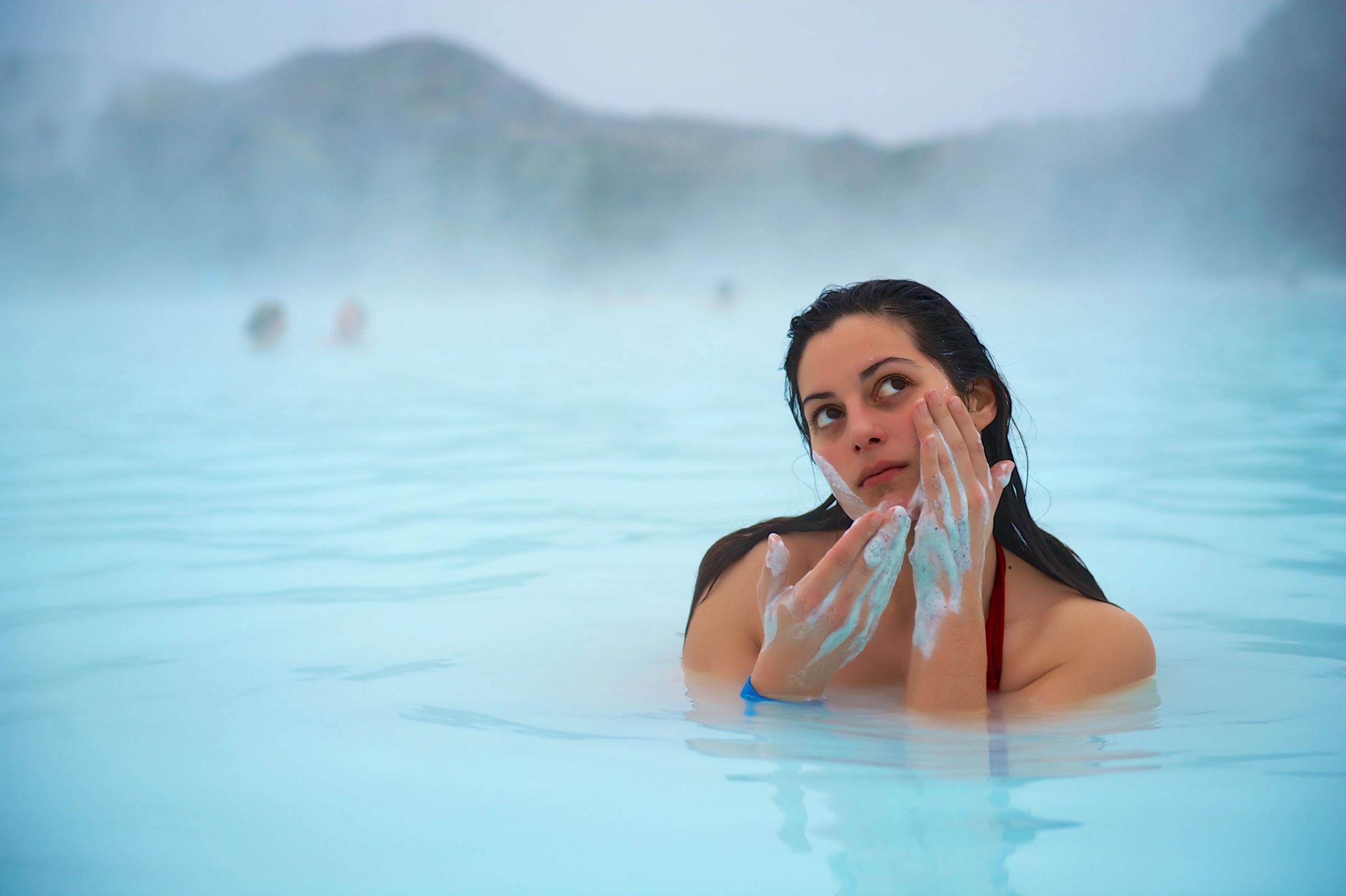 Girl put on mascara in the Blue Lagoon of Iceland