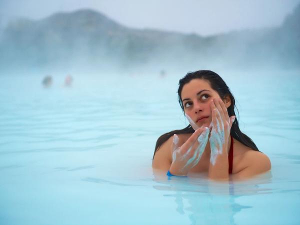Girl put on mascara in the Blue Lagoon of Iceland