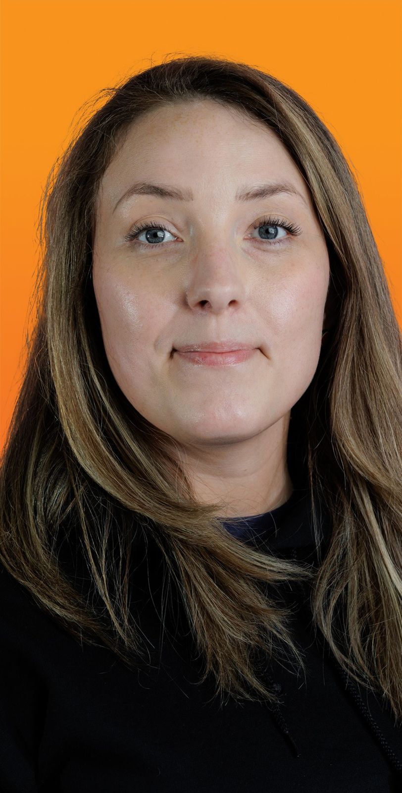 a close up of a woman 's face with an orange background
