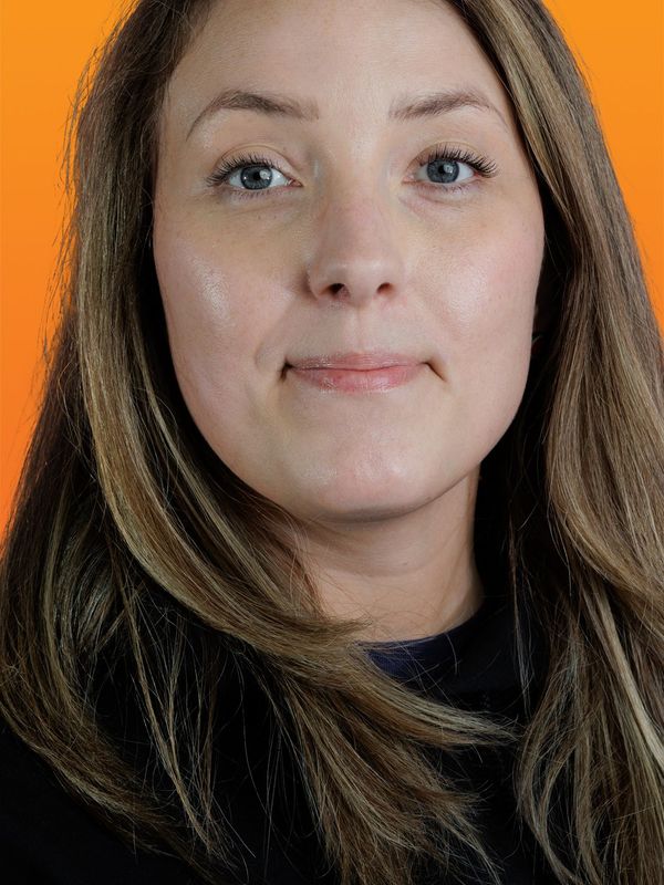 a close up of a woman 's face with an orange background