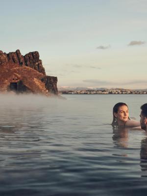Hot Spring in Iceland Woman and a man relaxing in Sky Lagoon hot spring Iceland