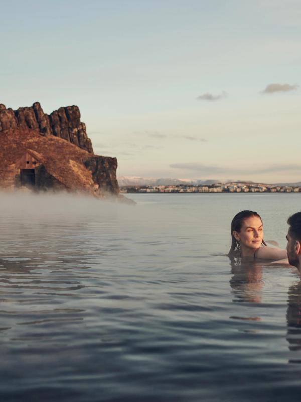 Hot Spring in Iceland Woman and a man relaxing in Sky Lagoon hot spring Iceland