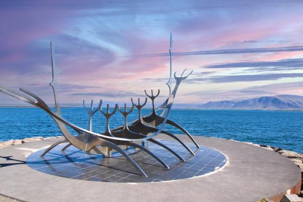 there is a statue of a boat in the middle of the ocean .