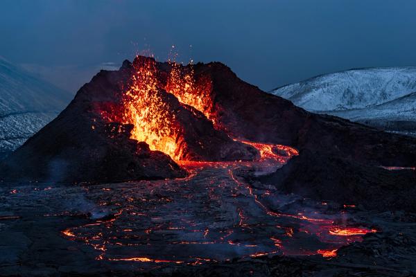 a volcano is erupting and lava is coming out of it .