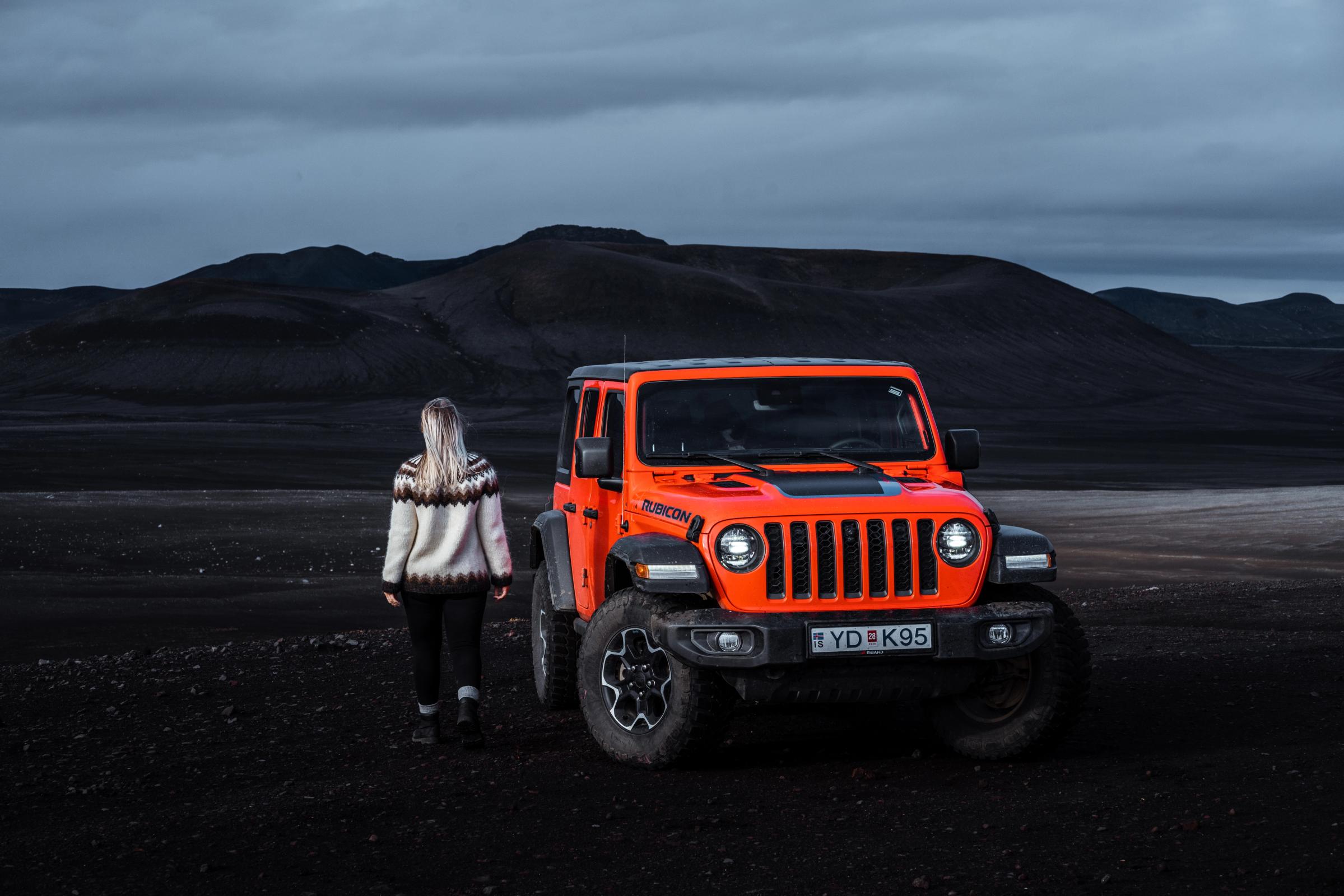 黄昏时分，一辆停着的 Jeep Wrangler Rubicon 4x4 旁站着一个人
