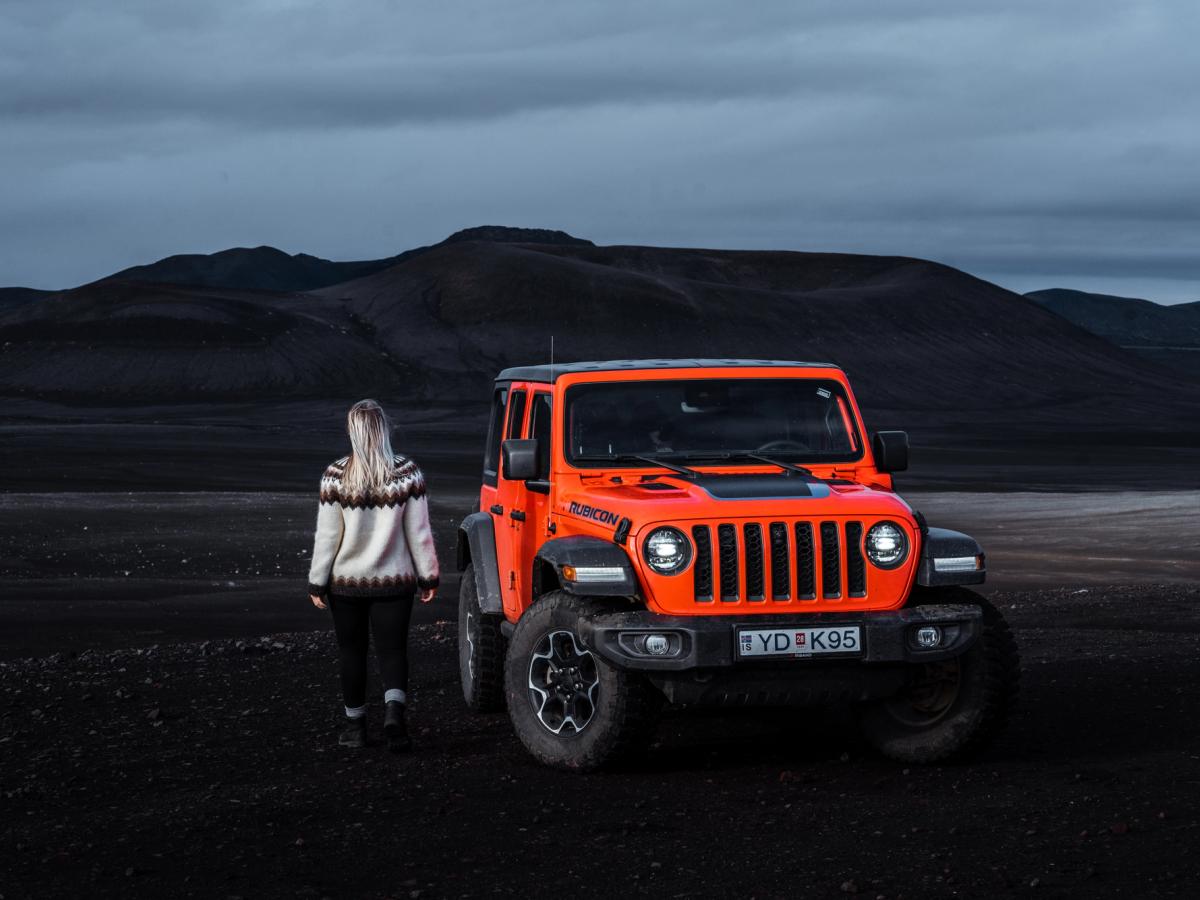 牧马人 Rubicon 黄昏风光 黄昏时分,一辆停着的 Jeep Wrangler Rubicon 4x4 旁站着一个人