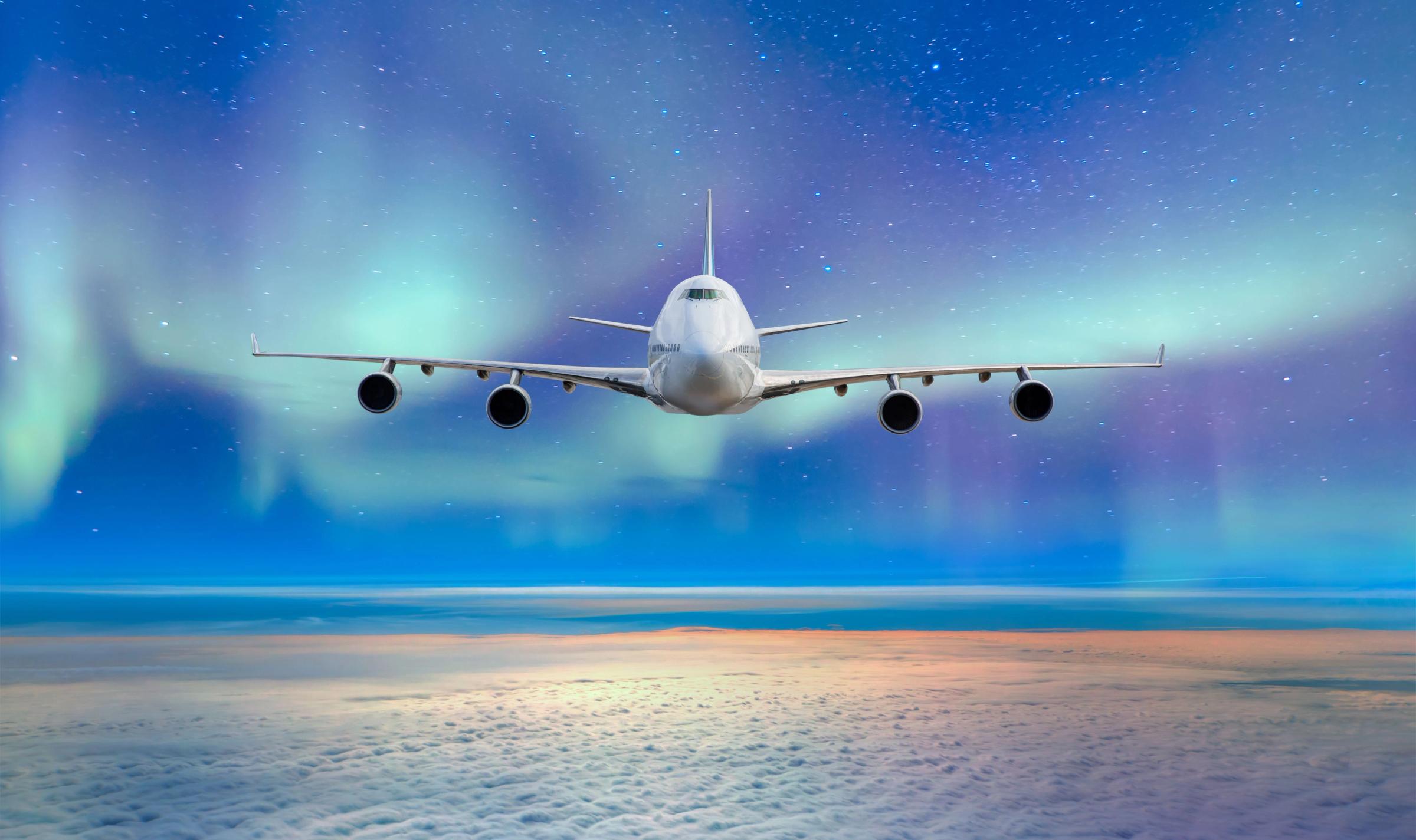 Plane flying under the Northern Lights