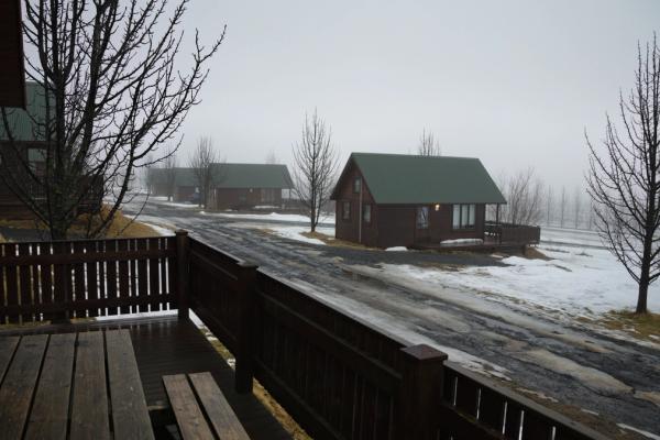 Casitas en un terreno nevado con una carretera con tierra al lado