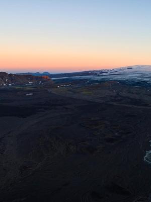 an aerial view of a mountain range with a river running through it at sunset .