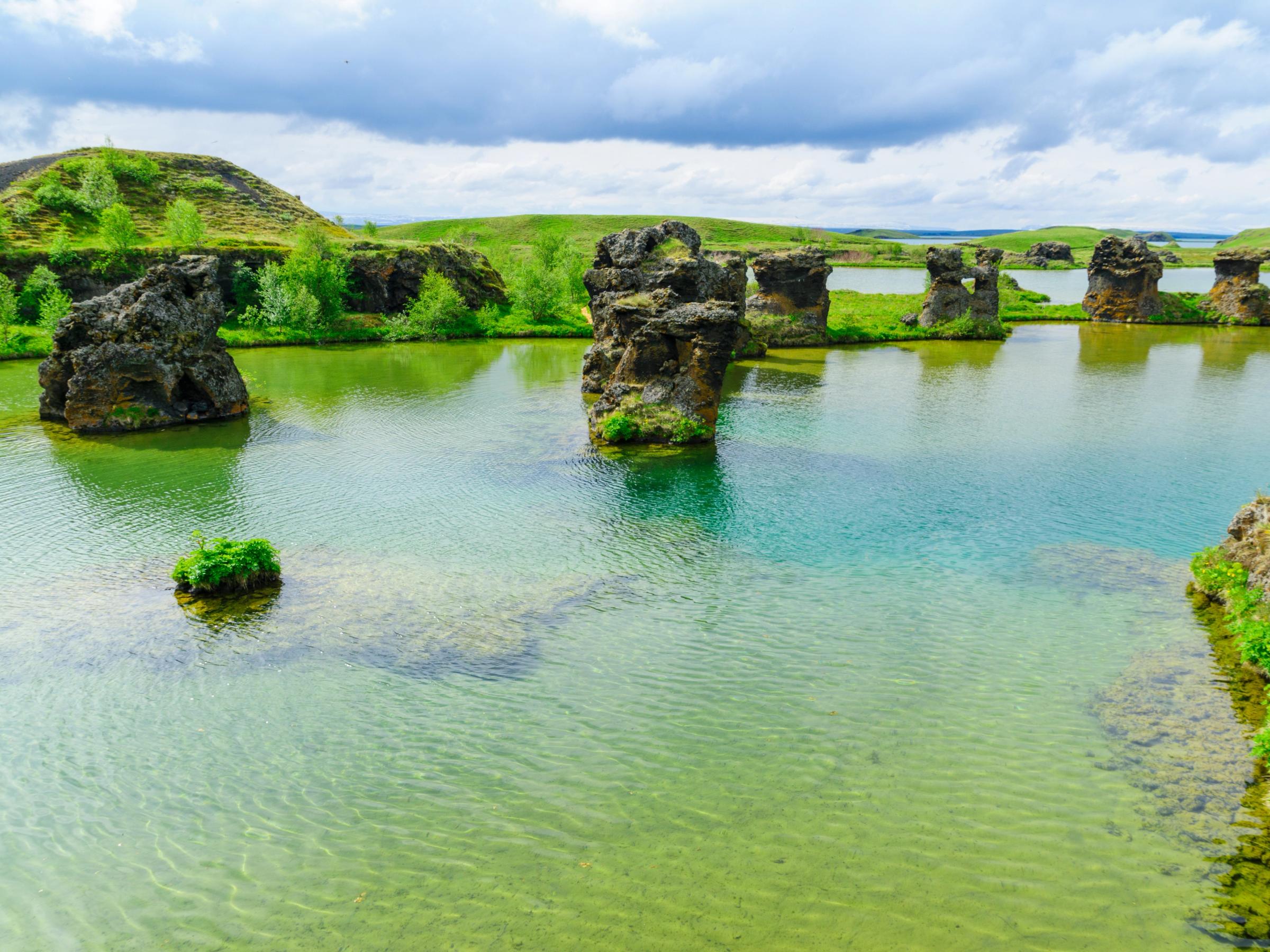 formaciones rocosas en un agua azul y verde del lago Myvatn